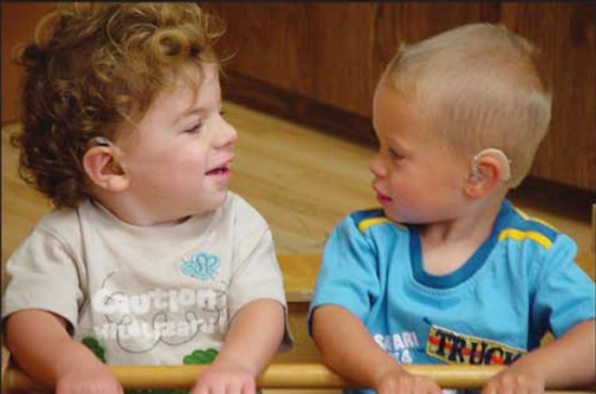 Two boys with hearing aids play together at Institute.