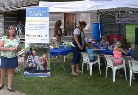 DSCC tent at state fair shows vertical banner with children coloring in the background