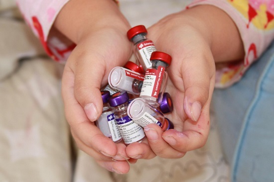 Cupped hands holding multiple vaccine vials