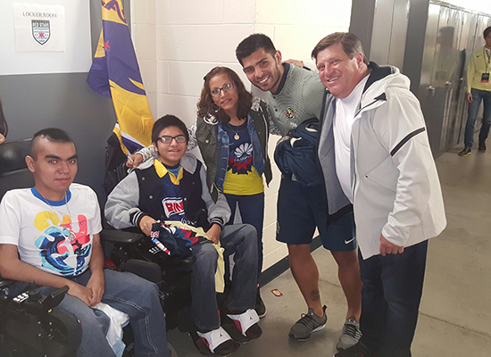 Brothers with muscular dystrophy pose with members of the Club America soccer team and their mother.