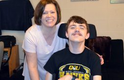 Cheryl and Jacob Flynn smiling together in their Quincy University apartment.