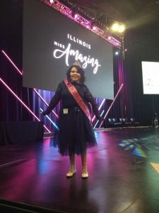 Izzy Gonzalez smiling on stage during the 2018 Illinois Miss Amazing event
