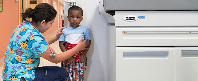 Pediatric nurse checks young boy's height