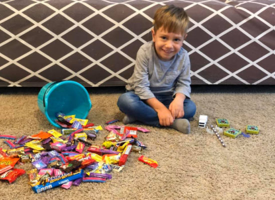 Axel Johnson sits with an overturned bucket of Halloween candy that he cannot eat