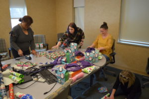 Springfield and Central Administrative Office staff wrap presents for Club Compass students. 