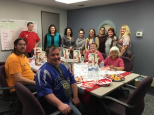 DSCC's Olney staff pose during their thank-you holiday party for the office's cleaning crew.