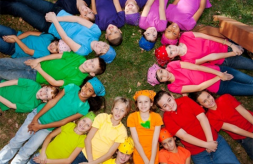 A diverse group of children forming a circle with their heads in the center