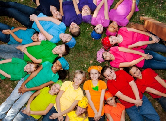 A diverse group of children forming a circle with their heads in the center