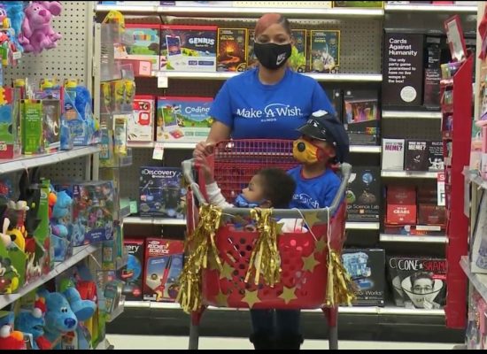 Shyterria Jordan pushes a decorated shopping cart with her son T'Aubrae and his big brother inside during a shopping spree