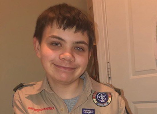 Nathan Lichucki smiles while wearing his Boy Scouts uniform