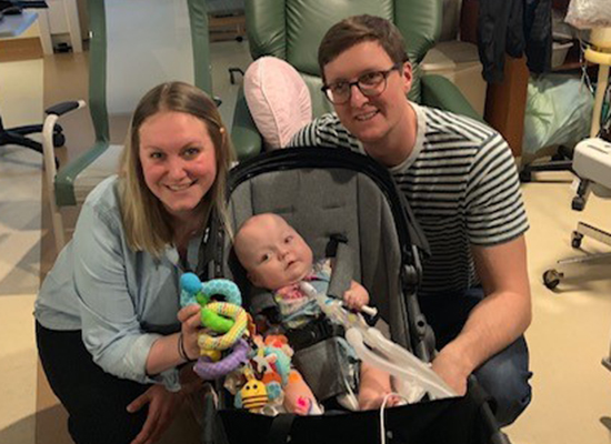 The Wolff family smiles and poses together in a hospital room