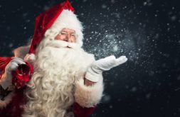 Santa with his bag and blowing magic snow out of his hand