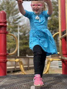 Home Care participant Willa plays on playground equipment outdoors