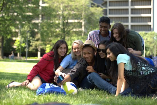 group of students taking a selfie in a grassy area of the UiC campus