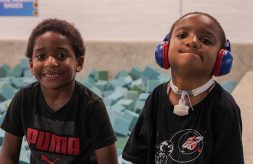 DSCC participant Dominic Garvin, 10, wears noise-cancelling headphones as he sits beside his younger brother on the edge of a foam block pit