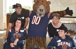 Daniel and Diana Barraza and their parents, Anita and Jose, pose with the Chicago Bears mascot while wearing Chicago Bears jerseys