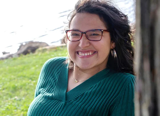 A close up portrait of Petra Petty smiling while sitting outdoors