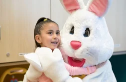 Little girl smiles while hugging the Easter Bunny