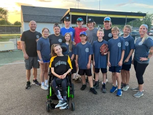 Lily smiles with the Fire Buddies baseball team