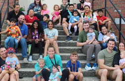 A group photo of Institute participants and their families on the dorm steps.