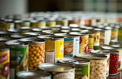 Canned food goods stacked together in multiple rows