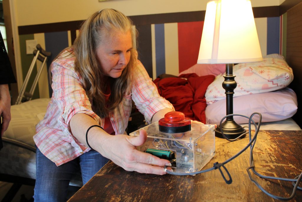 A parent sets up a SeizureSense Safety Alert System next to her bed so she can safely monitor her daughter at night.