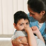A nurse holds a little boy with cerebral palsy