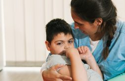 A nurse holds a little boy with cerebral palsy